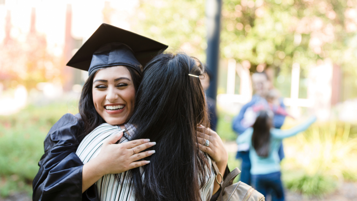 young woman hugs mother after graduation​