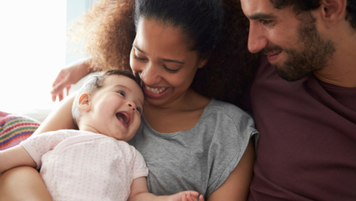 New parents holding infant child