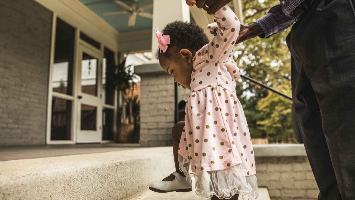 Man helping toddler climb steps